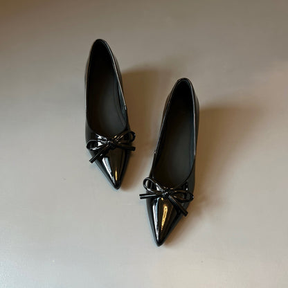 Zapatos de charol con elevación interna que estilizan la figura
