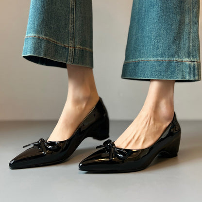 Zapatos de charol con elevación interna que estilizan la figura