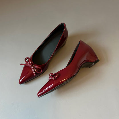 Zapatos de charol con elevación interna que estilizan la figura