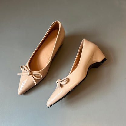 Zapatos de charol con elevación interna que estilizan la figura