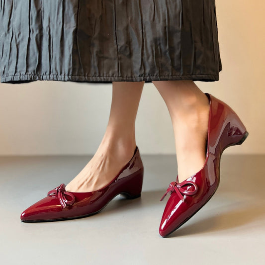Zapatos de charol con elevación interna que estilizan la figura